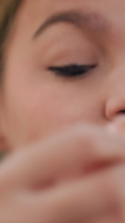 Applying false eyelashes carefully, Youthful woman meticulously placing false Stock Footage 326672135