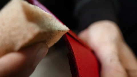 Applying finish to leather edge with sponge by hand Stock Footage 314961686