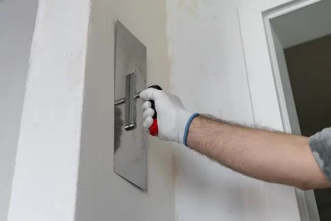 Applying finishing coat using trowel on drywall in modern construction Stock-Fotos