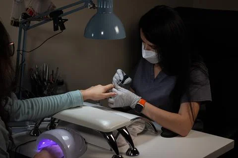 Applying finishing protective layer on artificial nails Stock Photos
