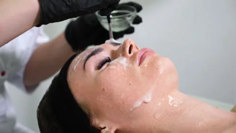 Applying foam on face in wellness spa Stock Footage 148098222