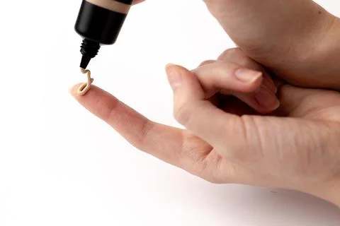 Applying Foundation on Finger: A Close-Up of Liquid Makeup Being Dispensed from Stock Photos