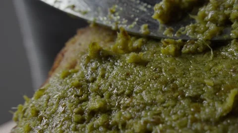 Applying Fresh Pesto on Bread Slice Stock Footage 285566346