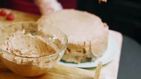 Applying frosting while turning a chocolate cake by hand, 4K Video stock 341121070