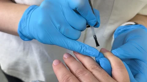 Applying gel nail polish during professional manicure, nail technician coating Stock Footage 345172949