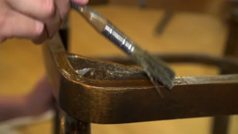 Applying glue with a brush on an old wood lacquered chair Stock Footage 155379904