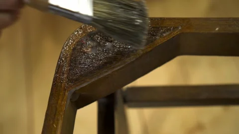 Applying glue with a brush on an old wood lacquered chair Stock Footage 155808701