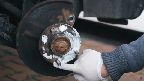 Applying graphite anti seize grease to wheel hub surface during brake assembly Stock Footage 341568882