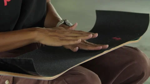 Applying grip tape to skateboard deck Stock Footage 321473949