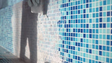 Applying grout to bathroom swimming pool tiles. Stock Footage 89576429
