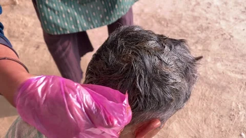 Applying Henna Paste on Gray Hair by Hand as a Natural Herbal Hair Dye Treatment Stock-Footage 327858635