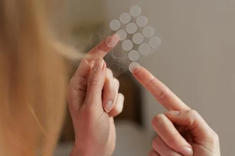Applying Hydrocolloid Acne Patch From Sticker Sheet Skincare Closeup 스톡 사진