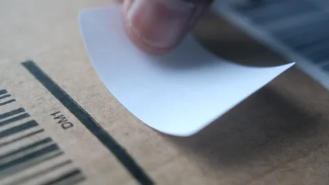 Applying a label to a cardboard box Stock Footage 296933111