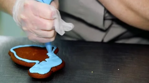 Applying a layer of glaze to a confectionery product using a pastry bag. Stock Footage 205062800