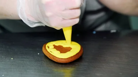 Applying a layer of glaze to a confectionery product using a pastry bag. Stock Footage 205062807