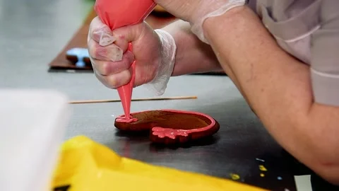 Applying a layer of glaze to a confectionery product using a pastry bag. Vídeo Stock 205555040