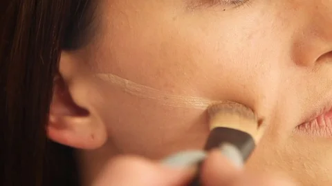 Applying liquid foundation on cheeks with brush Stock Footage 81294543