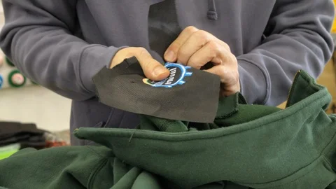 Applying the logo on the sweatshirt. Embroidery workshop, profession, creativity Vídeos de archivo 116415623
