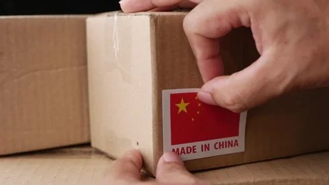 Applying MADE IN China flag label on a shipping box. Stock Footage 306659681
