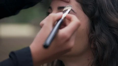 Applying make up with a brush on young woman's face,close up Stock Footage 74712694