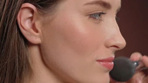 Applying makeup to the model's face artist uses a powder brush to finish Stock Footage 148271051