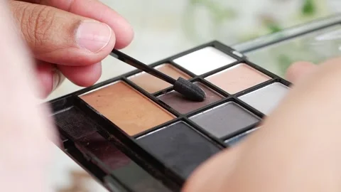Applying makeup using a palette in a bright setting Stock Footage 341786174