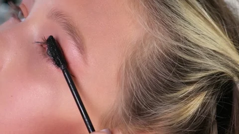 Applying mascara to eyelashes with makeup brush close up Stock Footage 341343741
