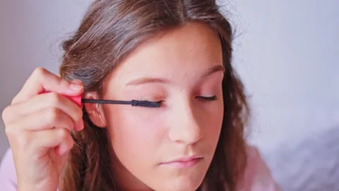 Applying mascara for a flawless makeup look at home during a morning routine Stock Footage 310506827