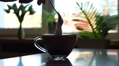 Applying milk froth with a spoon to aromatic hot coffee Stock Footage 154298236