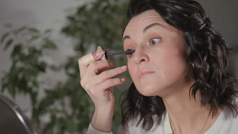 Applying the morning's makeup. The brunette creates a face drawing for herself Stock Footage 124152863