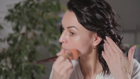 Applying the morning's makeup. The brunette creates a face drawing for herself b Stock Footage 124153872