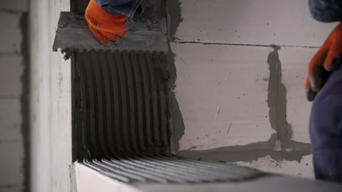 Applying Mortar With Notched Trowel on Block Wall Stock Footage 327811845