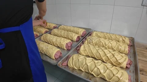 Applying Oil to Ham Bread Dough Cover Before Baking in Bakery Production Stock Footage 338120563