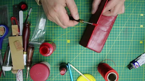 Applying paint to the edges red leather wallet DIY craft Stock-Footage 148049524