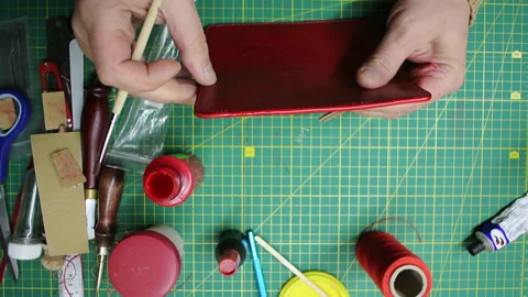 Applying paint to the edges red leather wallet DIY craft 스톡 동영상 148049527
