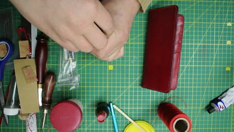 Applying paint to the edges red leather wallet DIY craft Stock-Footage 148049544