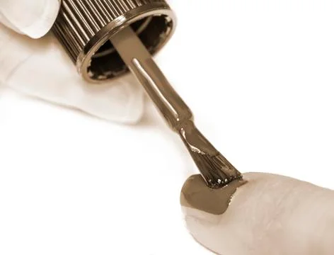 Applying paint to a nail Foto stock