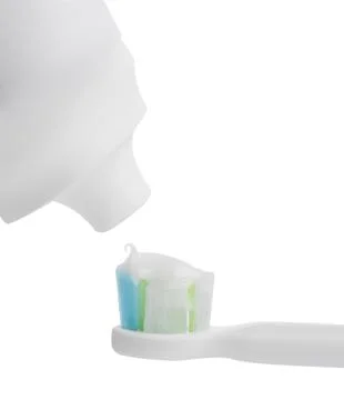 Applying paste on electric toothbrush against white background, closeup 스톡 사진