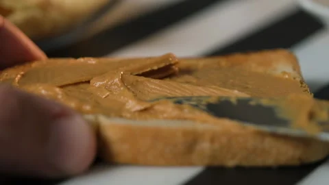Applying peanut butter on crispy toast bread Stock Footage 321954191