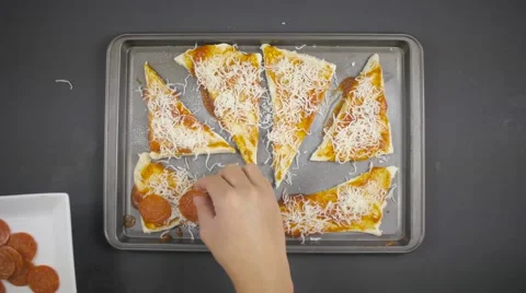 Applying pepperoni to pizza dough Stock Footage 61324602
