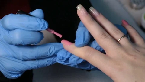 Applying pink nail polish on the nail Stock Footage