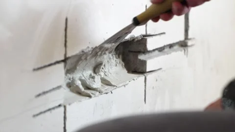 Applying plaster putty inside freshly drilled wall socket hole Stock Footage 339298309