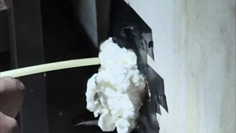 Applying Polyurethane Expanding Foam Spray to Seal Wall Gap Close Up Vidéo 346908502