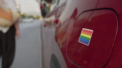 Applying Pride Sticker to Red Car Stock Footage 252734778
