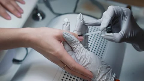 Applying primer to natural nail plate by manicure technician Stock Footage 343798389