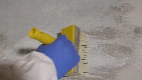 Applying primer to the wall by hand in white overalls. Stock-Footage 157435071