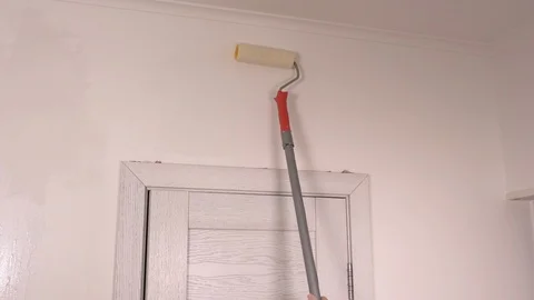 Applying primer on white wall with roller brush Stock Footage 105100591