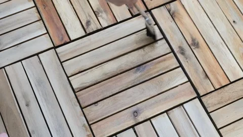 Applying Protective Oil to Wooden Deck with a Brush Stock Footage 284672833