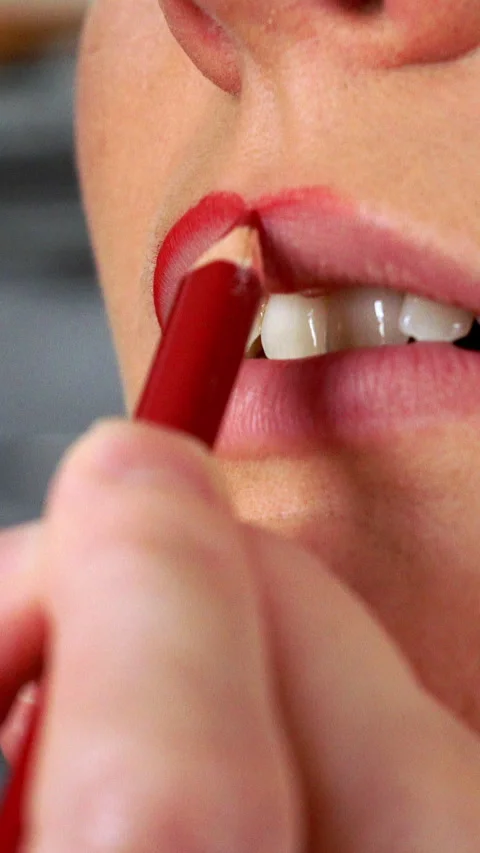Applying red lip liner to female lips. Vertical video Stock Footage 336428646