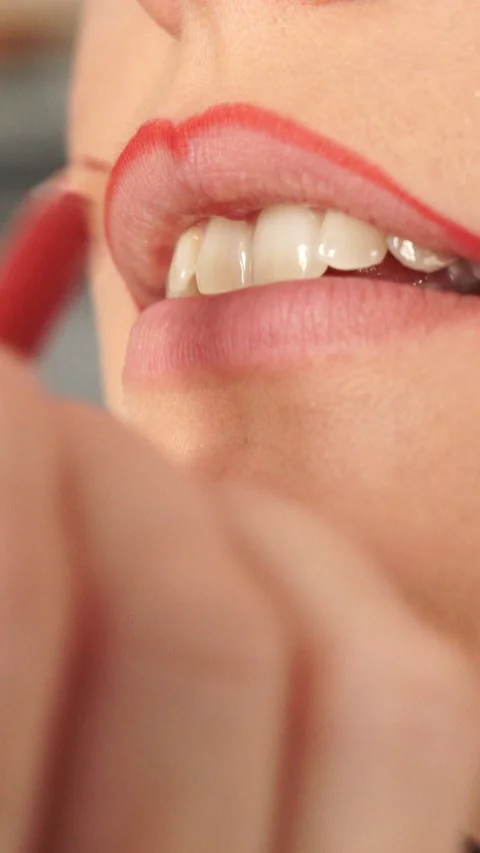 Applying red lip liner to female lips. Vertical video Stock Footage 336428730